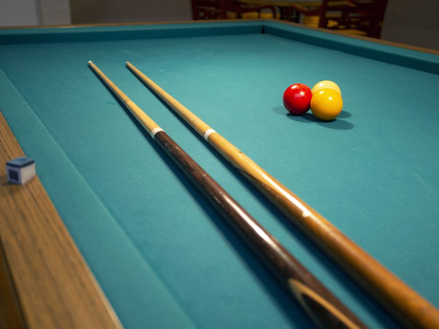 A green cloth billiards or pool table red,yellow and white ball,hobby and sport with copy space